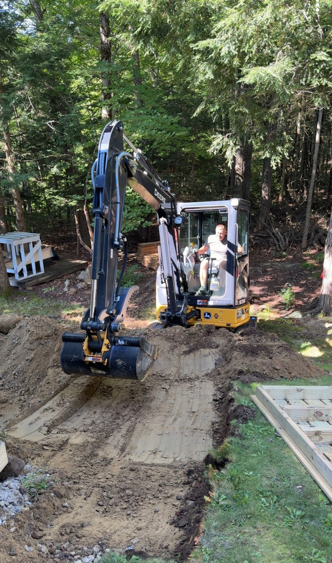 John Deere 35 mini excavator digging a trench on a residential job site in New Ipswich, NH